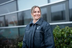 Glimlachende dame als beveiliger in opleiding in uniform tijdens opleiding Beveiliger N2.