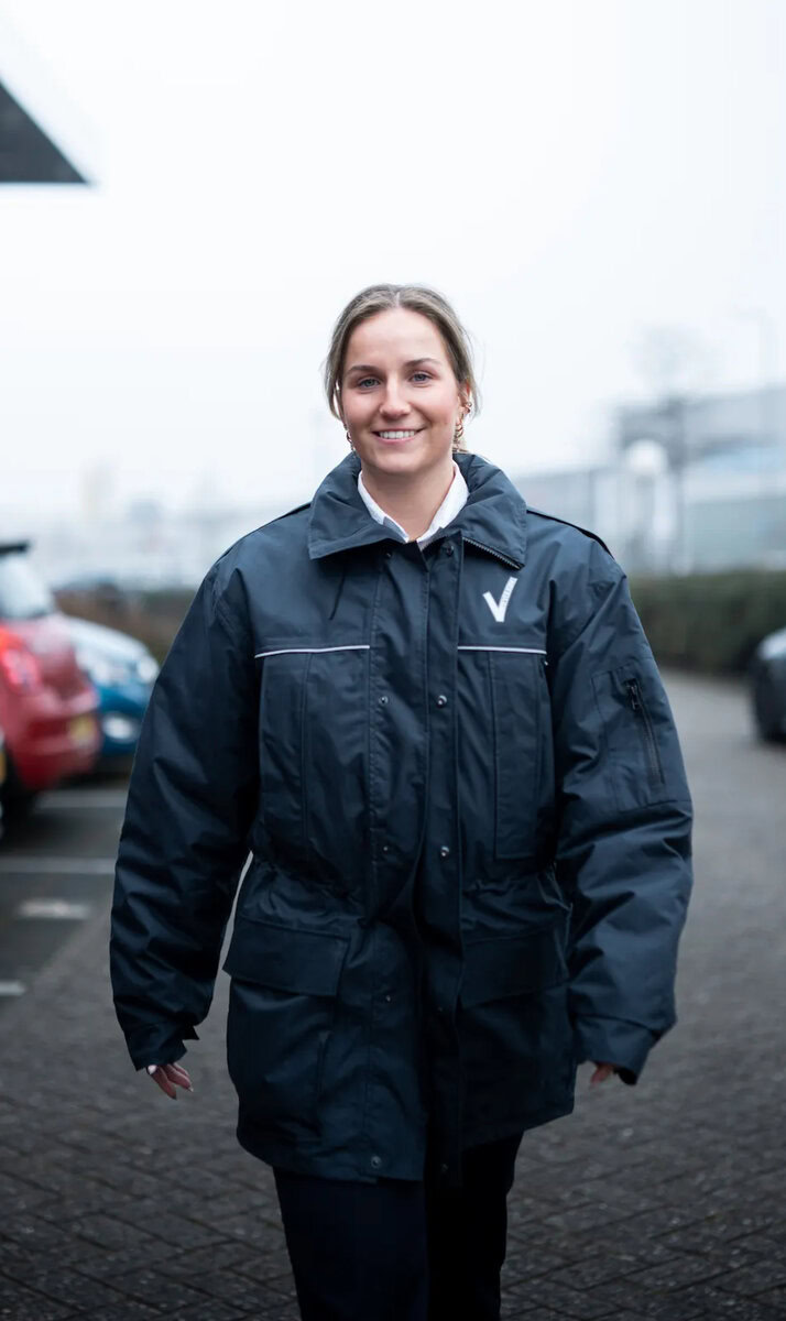 Beveiliger die lacht en naar je toe loopt