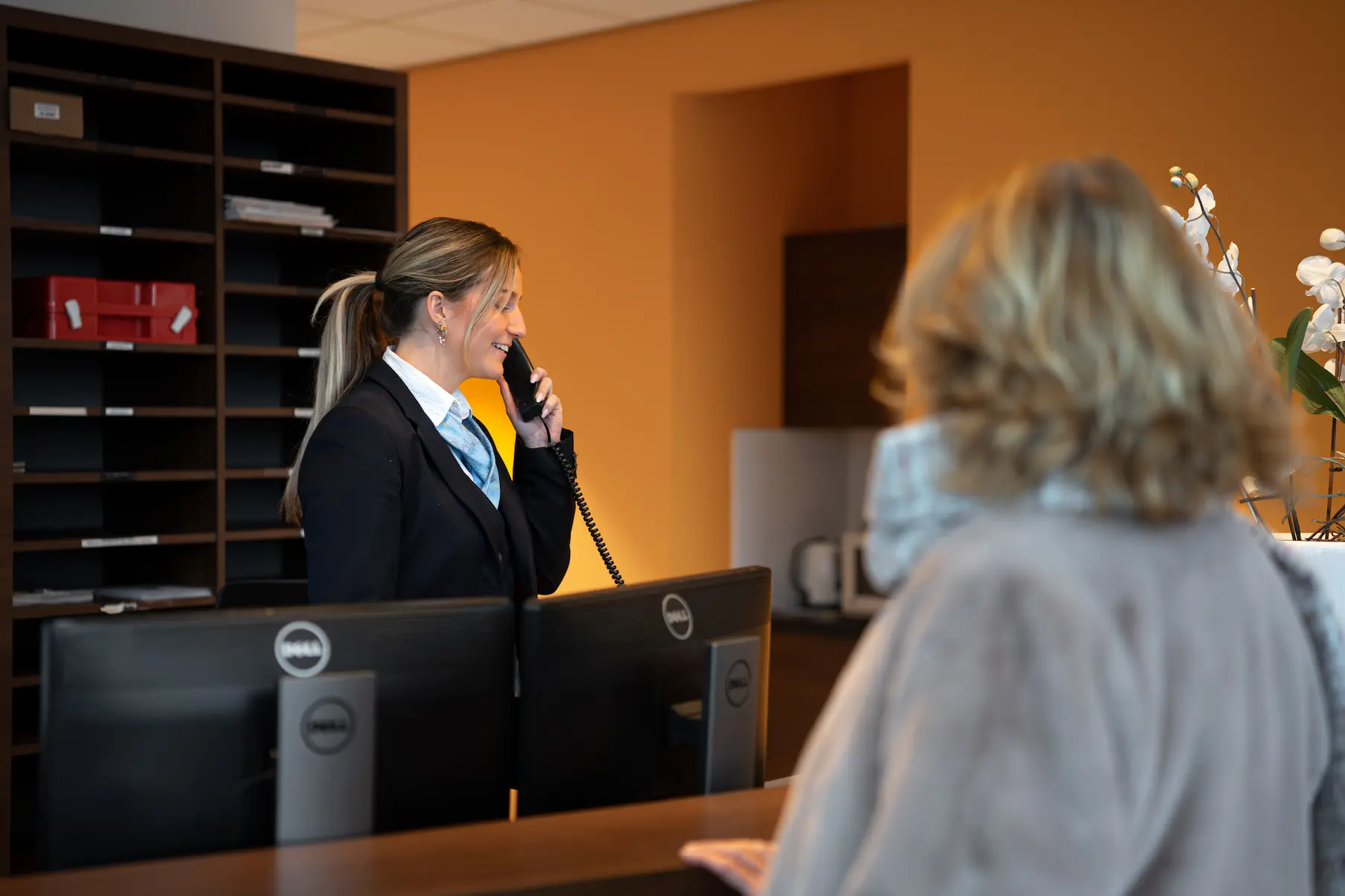 Receptionise die aan het telefoneren is.